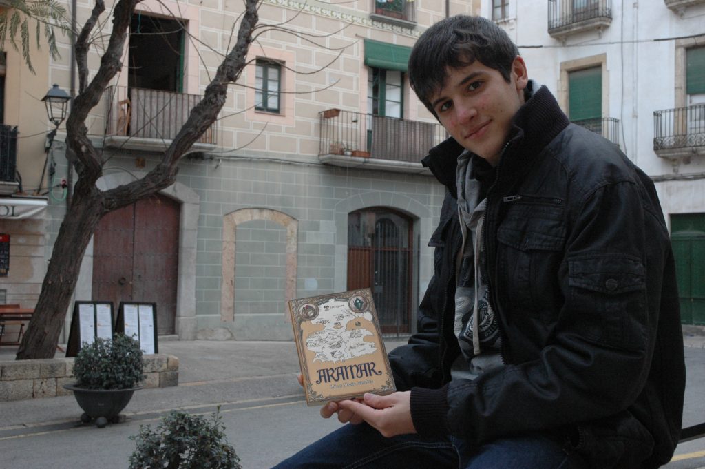 El jove Albert Masip sosté la portada del seu primer llibre, 'Aramar'
